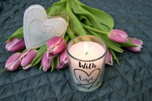 1. Świeca z napisem "With Love" i bukiet tulipan&oacute;w na świątecznym tle.